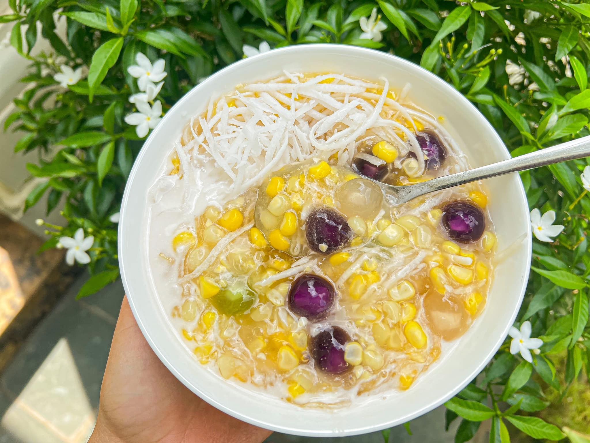 Golden corn kernels floating in creamy coconut milk with chewy glutinous rice pearls 